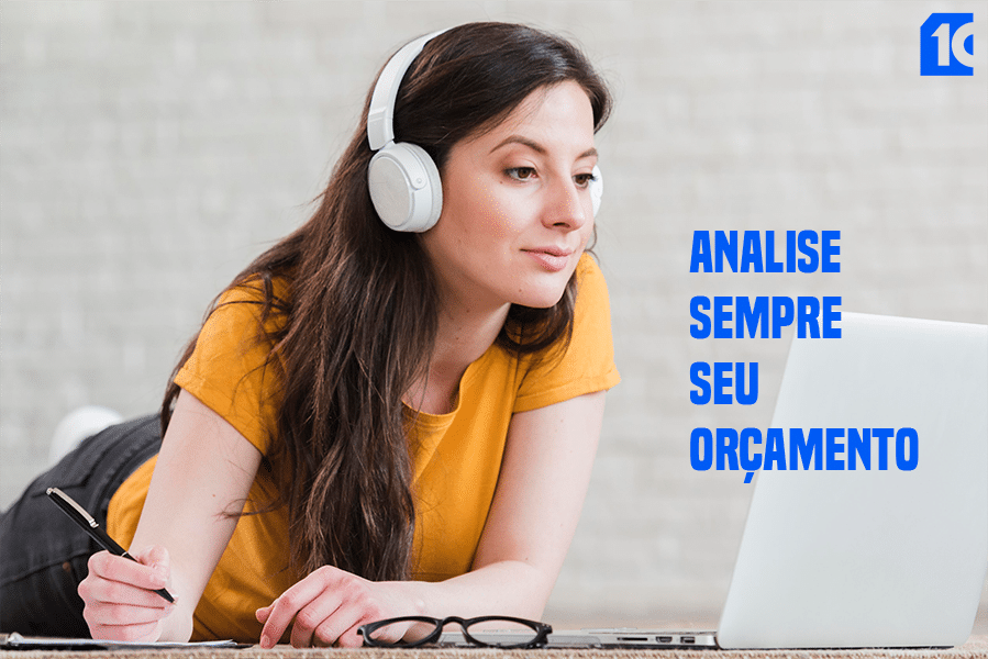 mulher olhando para laptop com vone de ouvido