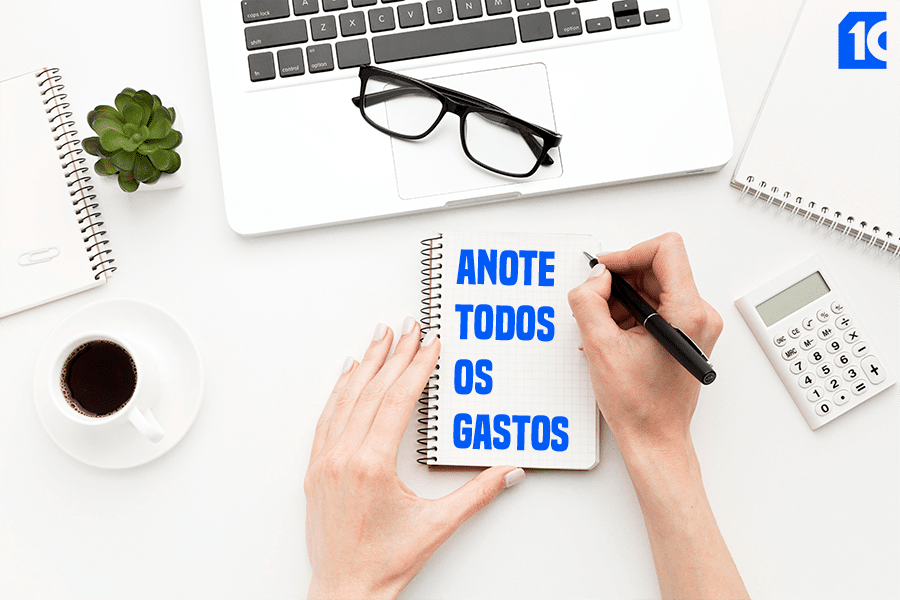 pessoa fazendo anotações em caderno e calculadora sobre mesa